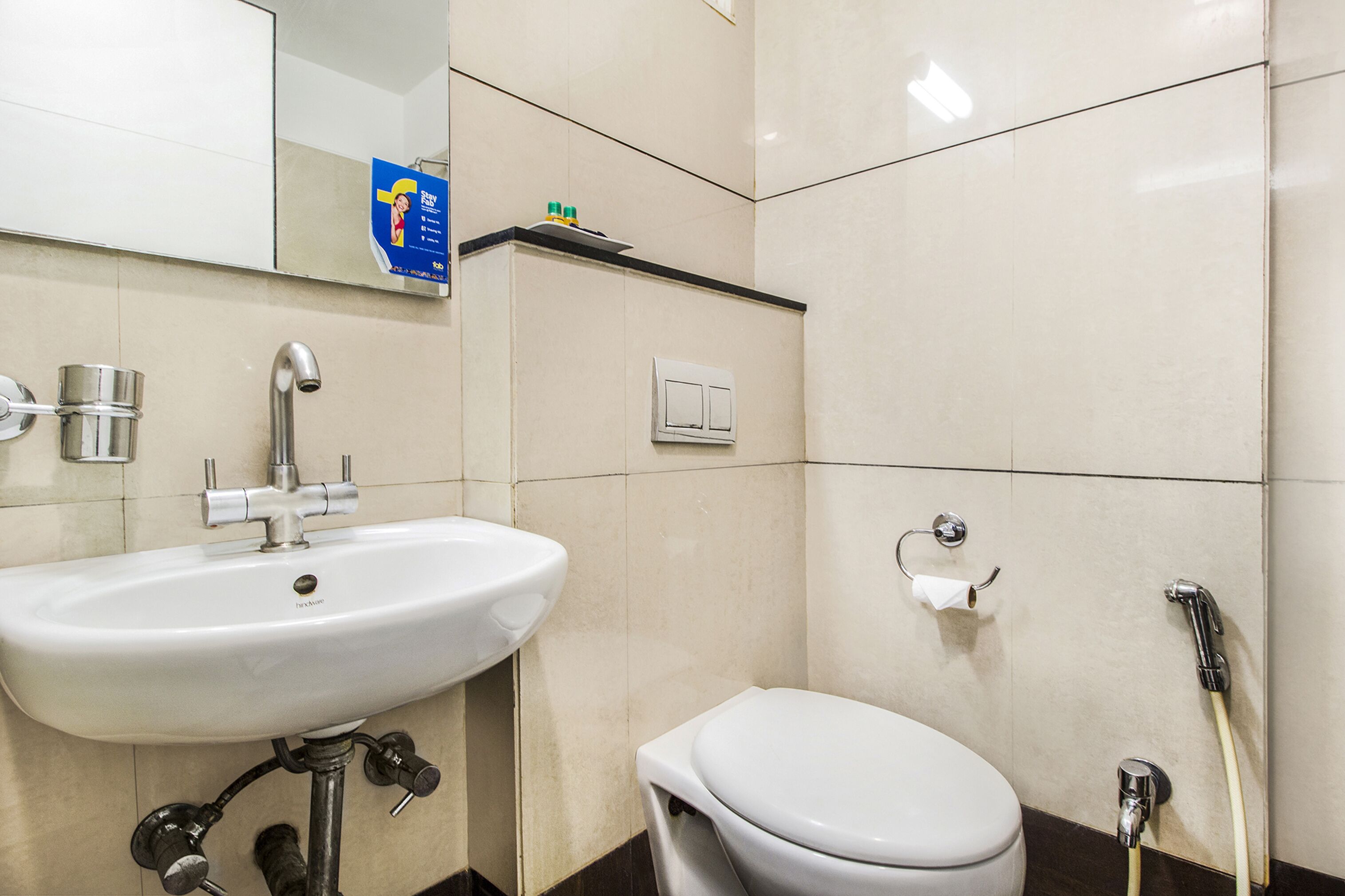 A bathroom with a white sink, a toilet, a shower, and a mirror.