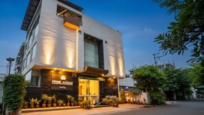 A modern hotel with a prominent entrance, large windows, and a well-lit facade. - Fabhotel Prime Avenue (Indore)