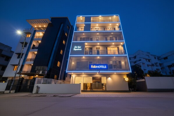 Ein mehrstöckiges Hotel mit modernem Design, mit einem gut sichtbaren 'fabHOTELS'-Schild im Erdgeschoss.