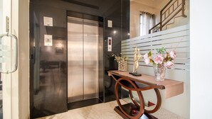 An elevator with a digital display, a push button, and a wall-mounted plaque. - Treebo Cabana (New Delhi)