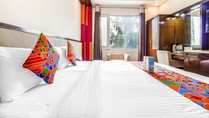 A hotel room with a large bed, a desk, a mirror, and a window with curtains. - FabHotel Marble Arch - Nr. Karol Bagh Market (New Delhi)