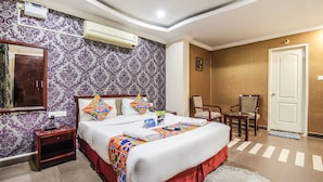 Une chambre d’hôtel avec un grand lit, une table de chevet, une chaise et une porte.