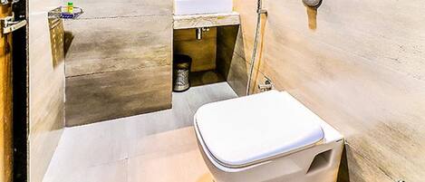 A bathroom with a toilet, sink, and shower.