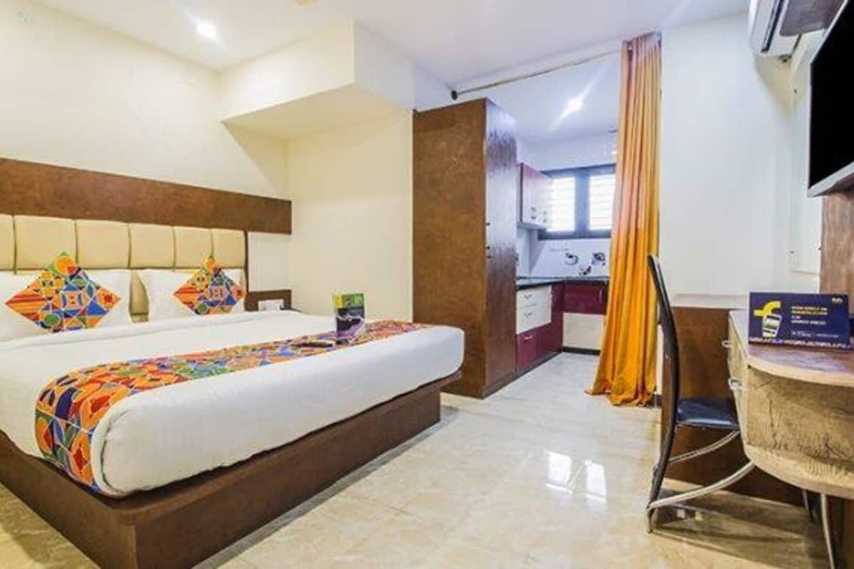 Ein Hotelzimmer mit einem Bett, einem Schreibtisch, einem Sessel und einem Fernseher.