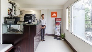 A reception area with a Samsung monitor, a glass counter, and a 'Fab Express' sign. - FabHotel Kalyan (Vadodara)