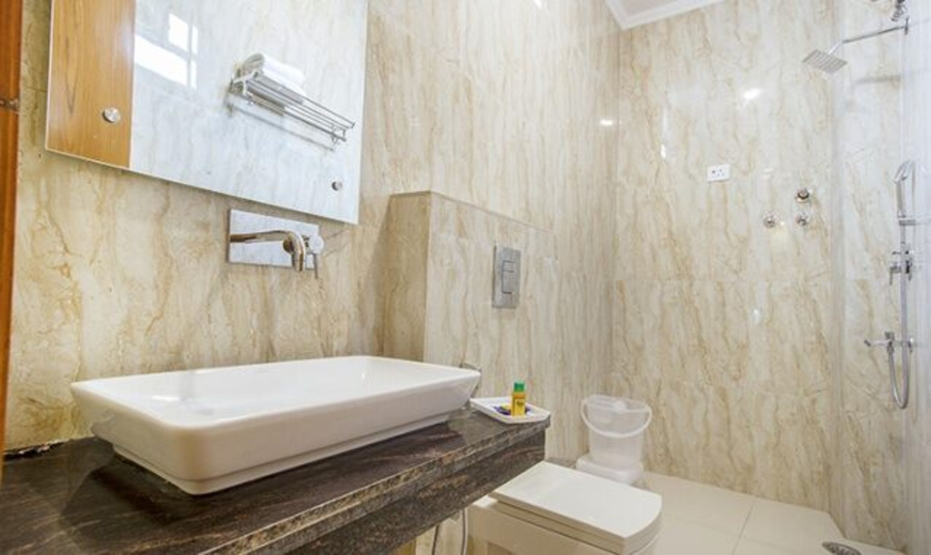 A bathroom with a large rectangular sink, a toilet, and a shower area.