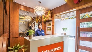 A hotel reception area with a wooden interior, a reception desk labeled 'Habexpress', and a view of the outside through a glass door. - FabHotel Marol Metro (Mumbai)