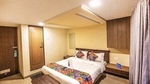A hotel room with a bed, bedside tables, a mirror, and a door. - FabHotel Silver Lake (Mumbai)