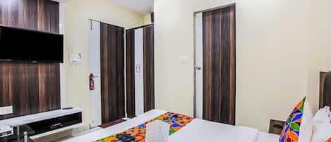 Una habitación de hotel con cama, televisión, escritorio y baño.