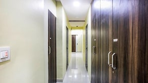 Un pasillo con armarios de madera y un interruptor de luz en la pared.
