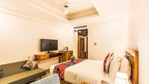 A hotel room with a bed, a TV, a desk, and a couch. - FabHotel Casa Kiara With Pool Side Bar, Calangute (Calangute)