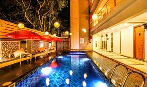 A pool area with a tiled floor, lounge chairs, and umbrellas. - FabHotel Casa Kiara With Pool Side Bar, Calangute (Calangute)