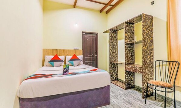 A bedroom with a bed, a chair, and a wardrobe.