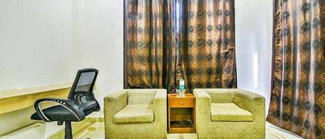 A room with two armchairs, a small table, and a chair.