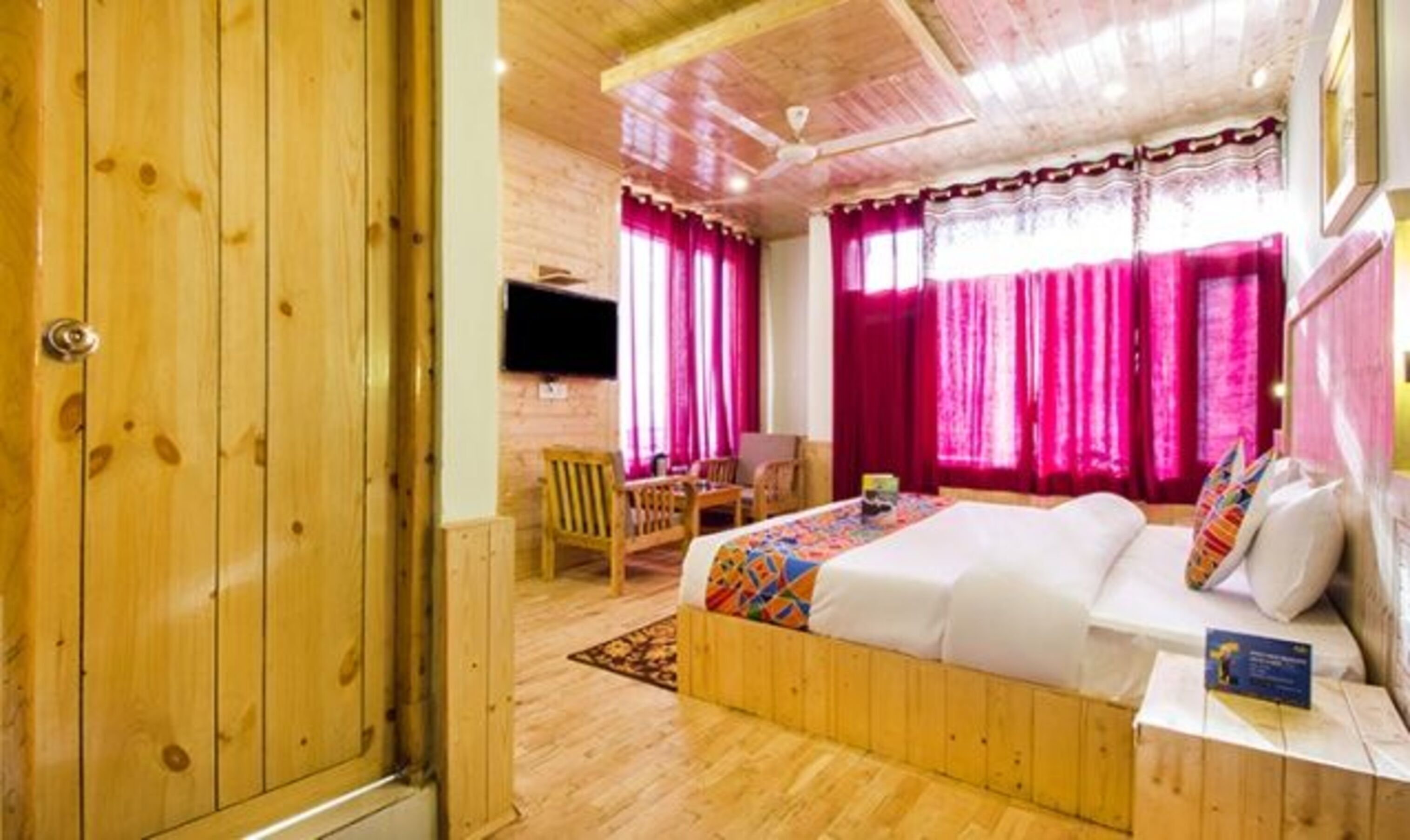 A wooden-paneled room with a bed, a desk, and a chair.