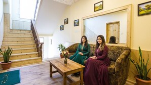 A room with a wooden staircase, a sofa, and two potted plants. - FabHotel Shami Inn (Manali)