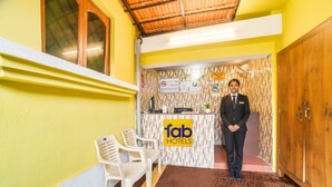 A hotel reception area with a reception desk, a sign reading 'fab hotels,' and a reception staff member. - FabHotel La Pablo - Nr. Chapora Fort (Vagator)