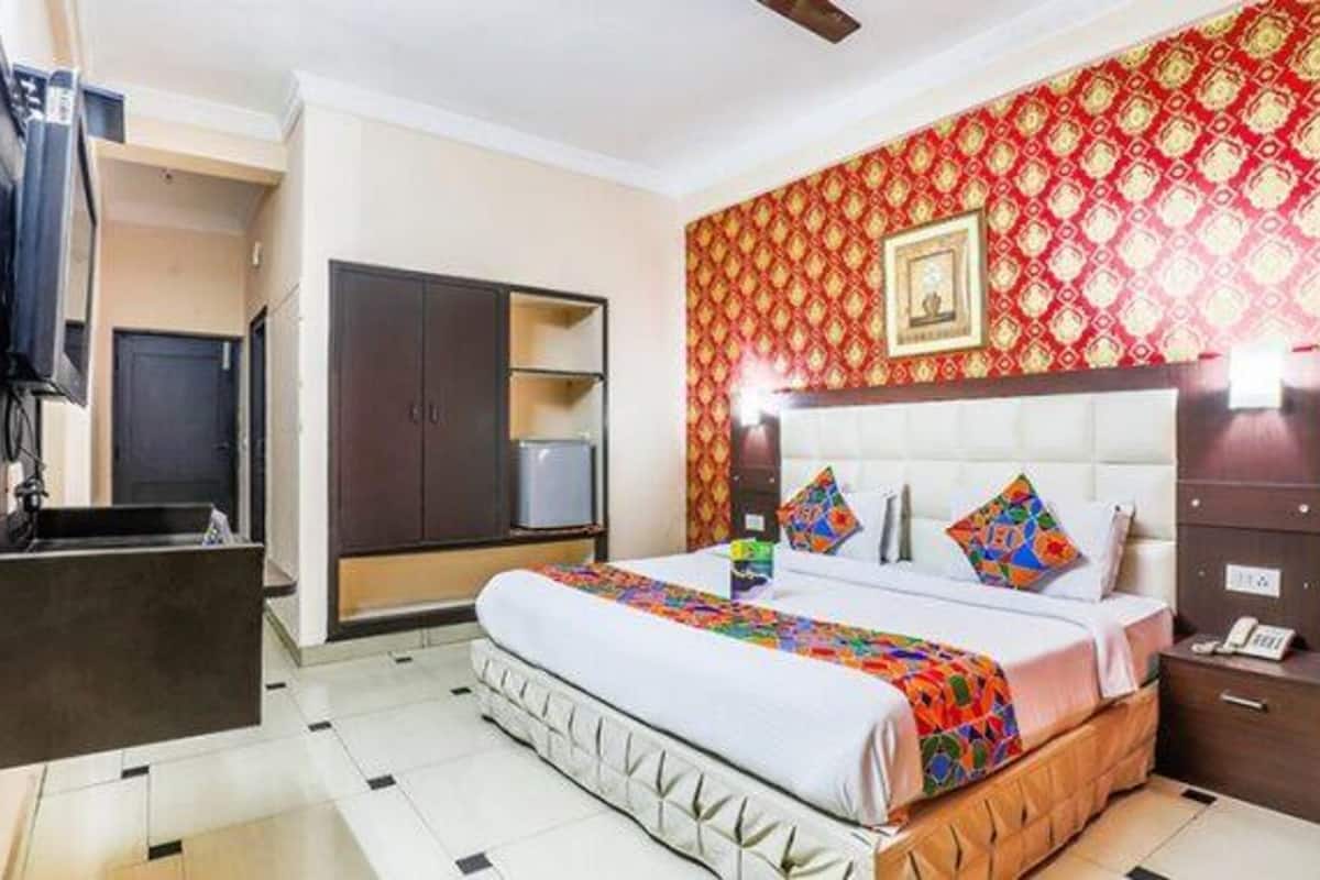 A hotel room with a bed, a wardrobe, a desk, and a television.