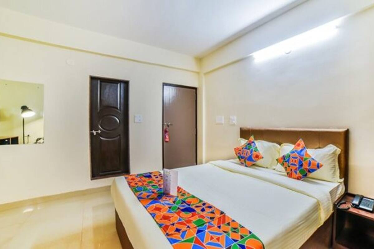 A hotel room with a bed, a desk, and a wardrobe.