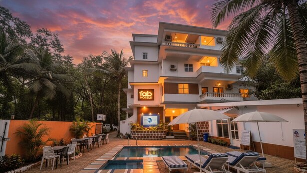 A modern hotel with a swimming pool, outdoor seating, and a sign reading "fab hotels". - FabHotel K7 Trends With Pool, Baga Beach (Calangute)