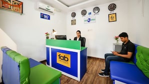 A hotel reception area with a reception desk, a clock, and a wall-mounted air conditioner. - FabHotel K7 Trends With Pool, Baga Beach (Calangute)