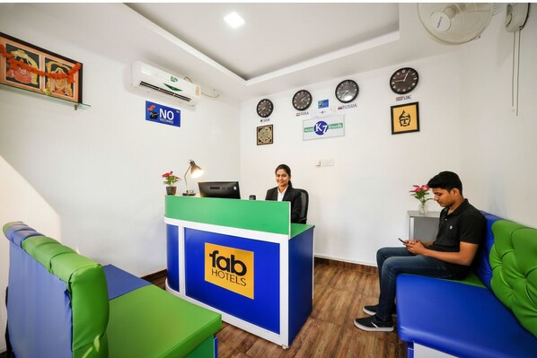 A hotel reception area with a reception desk, a clock, and a wall-mounted air conditioner. - FabHotel K7 Trends With Pool, Baga Beach - Nr. Calangute Beach (Calangute)
