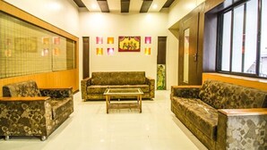 A spacious living room with a sofa set, a coffee table, and a large window providing natural light. - FabExpress Karishma - Shivaji Nagar, Pune (Pune)