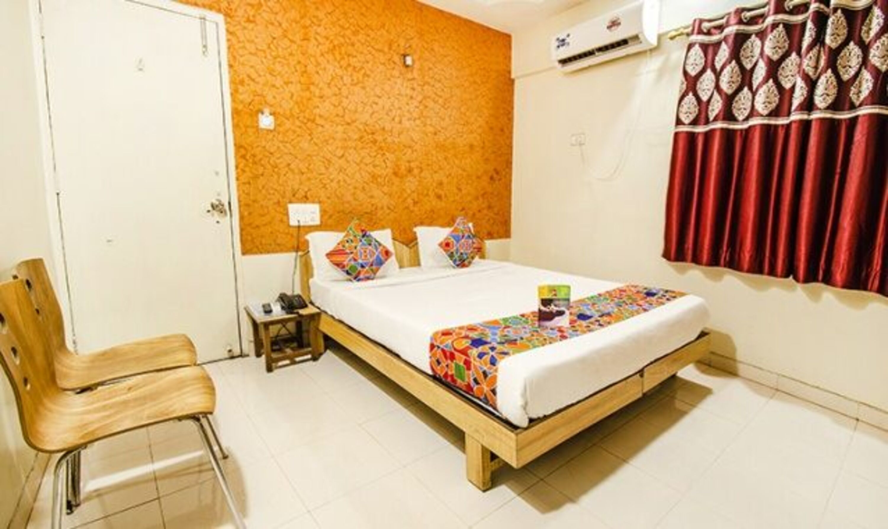 A bedroom with a wooden bed, a nightstand, a chair, and a red curtain.