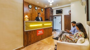 Una mesa de recepción con un cartel que dice 'Tab Express', paneles de madera y tres relojes en la pared.