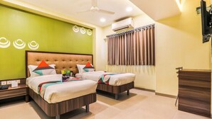 A hotel room with two beds, a green wall, a ceiling fan, an air conditioning unit, and a window with curtains. - Fabhotel Landmark Residency (Navi Mumbai)