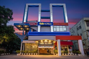 Un edificio con varios letreros, incluyendo 'fabHOTELS', 'DISCO THEQUE' y 'BAR FORK-N-CORK'.