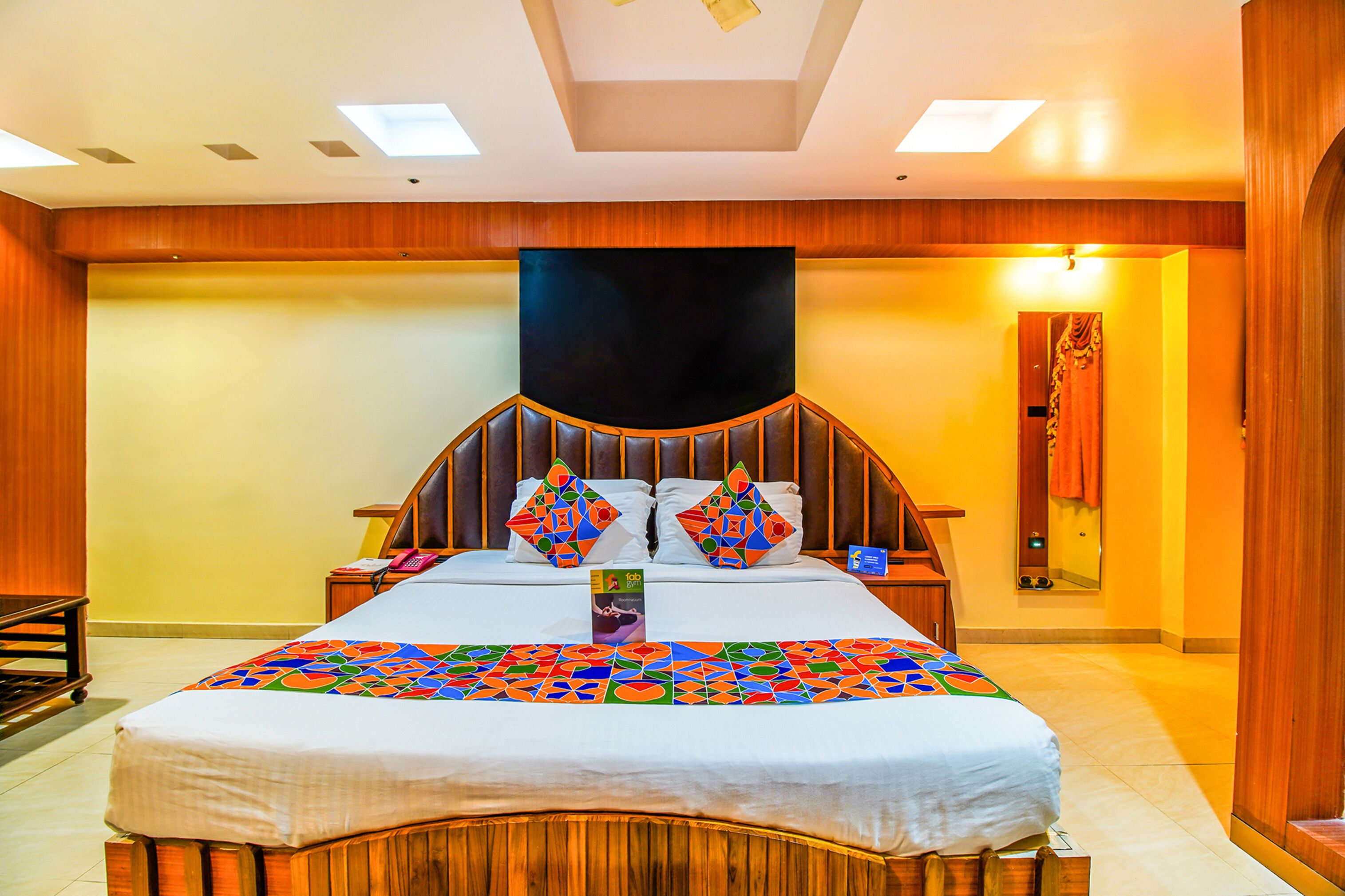 Une chambre d’hôtel avec un grand lit, une tête de lit en bois et un plafond doté de lucarnes.