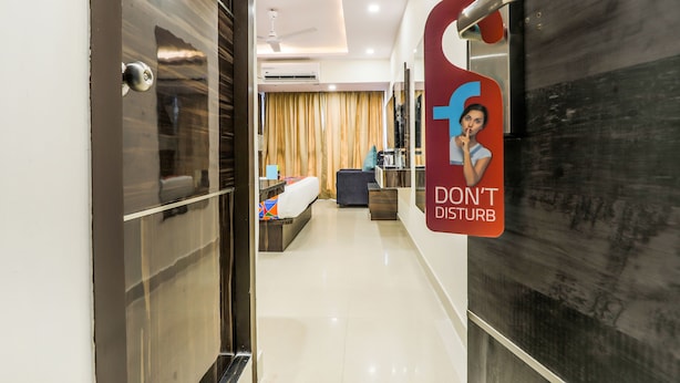 A hotel corridor with a 'DON'T DISTURB' sign, a modern interior design, and a glimpse of the room layout. - FabHotel Crown Heights - Nr. Kormangala Club (Bengaluru)