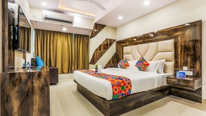 A modern hotel room with a large bed, a wooden desk, and a flat-screen TV. - FabHotel Crown Heights - Nr. Kormangala Club (Bengaluru)