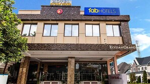 A hotel named Elysian Grand with a modern facade, a visible entrance, and a sign for Fab Hotels. - Fabhotel Elysian Grand (Lucknow)