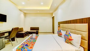 Una habitación de hotel con una cama, un escritorio y una silla.