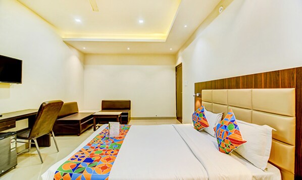 A hotel room with a bed, a desk, and a chair.