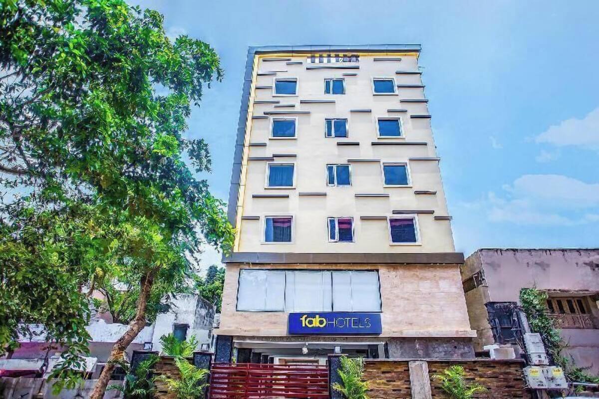 A multi-story building with a sign for 'fab hotels' on the ground floor.