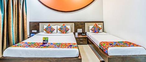 A hotel room with two beds, a wooden headboard, and a curved ceiling light.