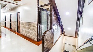 A modern hotel corridor with a polished floor, a wooden accent wall, and a glass door. - Fabhotel The Adore Palace (Mumbai)