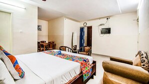 A hotel room with a bed, a chair, a desk, and a television. - Fabhotel Aditya Yatri Nivas (Tirupati)