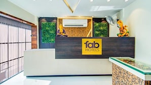 A reception desk with a 'fab hotels' sign, air conditioning, and decorative elements. - FabHotel Nayyar Inn (Amritsar)