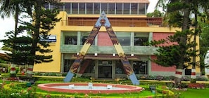 Un edificio con un patio central, una fuente y una gran escultura decorativa.