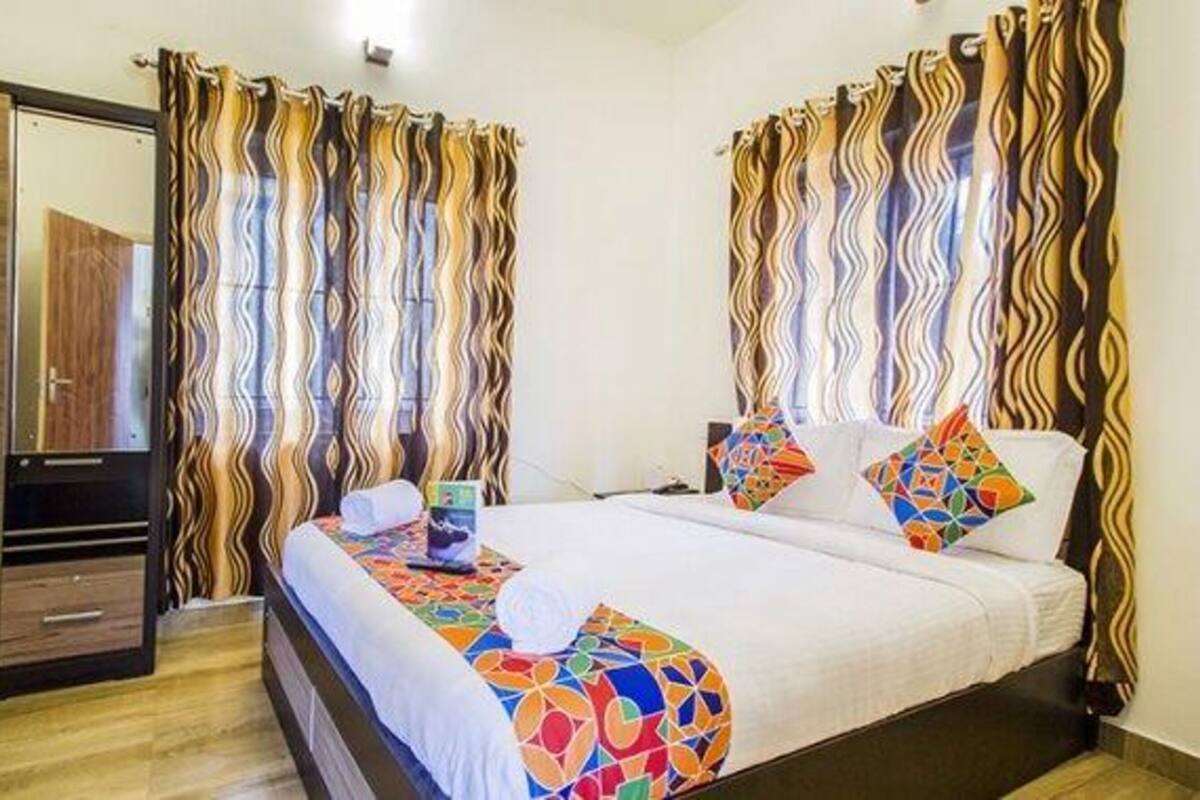 Habitació d'hotel amb llit, un armari i cortines.