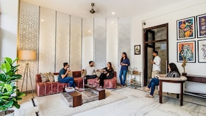 Una sala de estar moderna con un sofá rojo, una mesita de centro y un panel decorativo en la pared.
