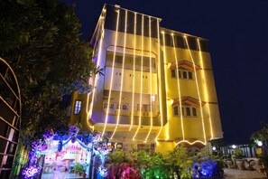A multi-story building with balconies and a well-lit facade. - FabHotel Astoria House (Bidhannagar)