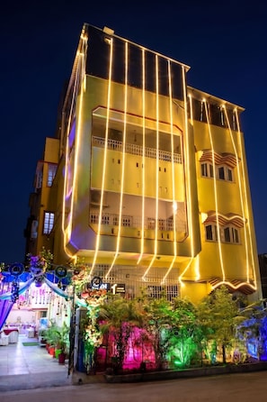 Un edificio de varios pisos con balcones y acceso principal a nivel de calle.