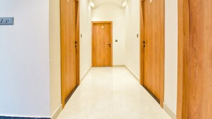 Un pasillo con puertas de madera y piso de baldosas.