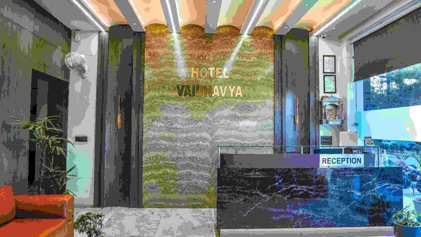 Zona de recepción con un cartel que dice "HOTEL VAIHAVYA" y un mostrador de recepción.