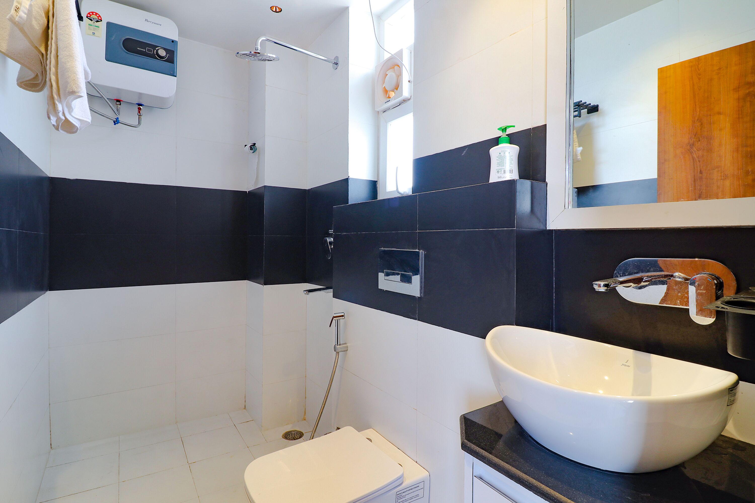 A modern bathroom with a white bathtub, a large mirror, and a shower area.